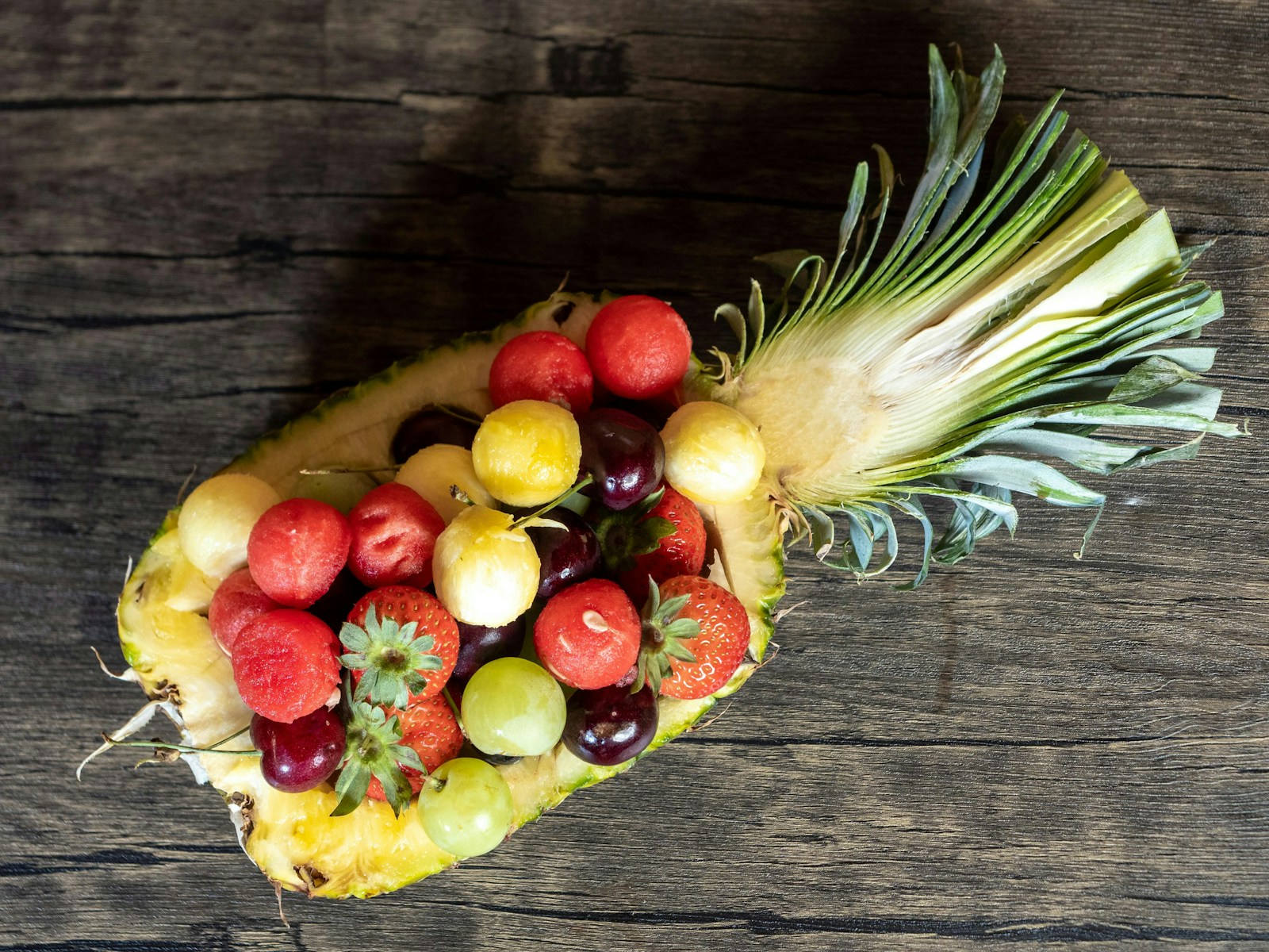 A pineapple filled with lots of different types of fruit
